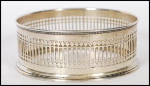 A early 20th Century silver hallmarked wine bottle coaster having pierced and gadroon decoration.