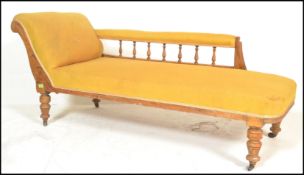 A late Victorian oak chaise longue day bed being raised on turned legs with yellow velour upholstery