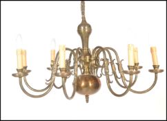 A 19th century style Dutch brass eight branch chandelier, with eight scrolling branches emanating