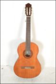 A Yamaha C40 six string acoustic guitar having a shaped hollow body with white tuning pegs and paper