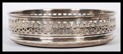 A silver Victorian hallmarked wine bottle coaster having a pierced gallery surround. London