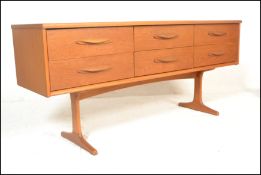A retro 20th Century teak wood sideboard credenza having a configuration of six drawers raised on
