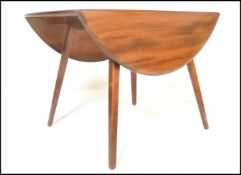 An Ercol Golden Dawn elm and beech drop leaf dining table, raised on upon square tapering legs.