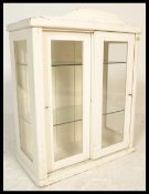 An early to mid 20th Century glazed apothecary counter top cabinet, constructed from pine with