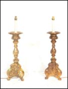 A pair of 20th Century gilt wood carved electric table lamps in the Rococo taste, raised on scrolled