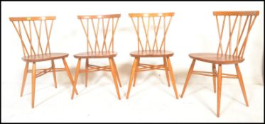 A set of four mid 20th century Ercol Windsor Candlestick back dining chairs in light elm and beech