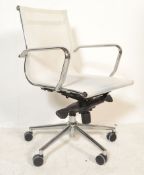 A retro desk swivel arm chair in the manner of Charles and Ray Eames being raised on chromed
