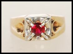 A stamped 14ct gold ring claw set with a round cut synthetic ruby. Size S. Weight 6.3g.