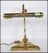 An 20th century brass bankers lamp, having a floral ornamental body and cylindrical shade.
