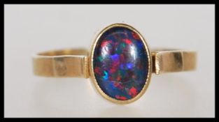 A stamped 375 9ct gold ring set with an opalescent cabochon. Weight 1.7g. Size N.