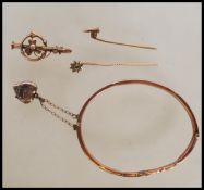 A hallmarked 9ct gold bangle with engraved foliate and swirl decoration, having hinged opening