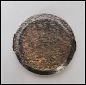 A vintage silver hallmarked Kigu compact of round form having a bark effect exterior and mirror to
