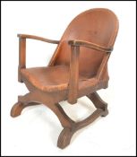 An early 20th Century open framed tub armchair, upholstered in brown tan leather with studded detail