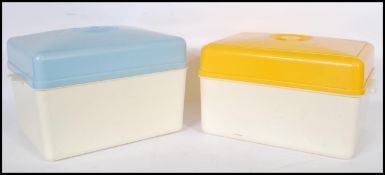 A pair of mid 20th Century retro bread bins, one having a yellow top and the other a blue top with