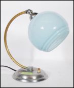 A Art Deco desk / table lamp, having a chrome circular base, brass bend support and a baby blue
