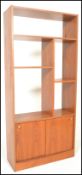 A retro 20th Century teak wood room divider having a configuration of shelves and cupboards.