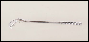 A stamped 18ct white gold brooch in the form of a golf club. Weight 3.1g. Measures 5.5cm long.