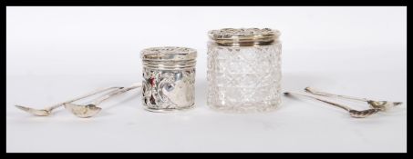 A pair of silver hallmarked and cut glass dressing table pots with rococo silver tops together