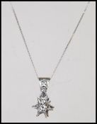 An 18ct white gold diamond necklace pendant in the form of  a starset with a diamond adorned bale