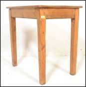A vintage early 20th century chunky country pine scrub top dining table being raised on squared legs