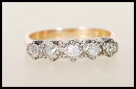 An 18ct gold and diamond five stone ring. The ring having five graduated diamonds within star