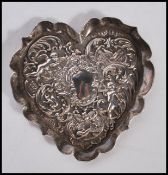 A silver hallmarked rococo heart shaped pin dish, the heart shaped dish decorated in relief with