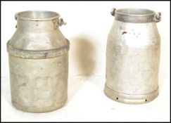 A pair of 20th Century industrial dairy farm galvanised milk churns having swing carrying handles.