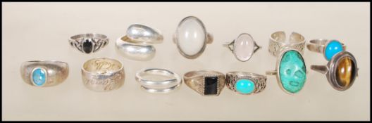 A collection of silver rings to include two moonstone cabochon rings, a tigers eye cabochon ring,
