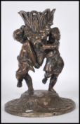 A cast bronze centrepiece epergne base depicted with two cherubs holding up floral garland decorated