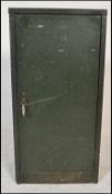 A vintage Industrial metal locker cabinet having green military paint work. The full length door