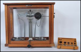 AN early 20th Century mahogany glazed cased apothecary / chemists scales by Griffin and George,