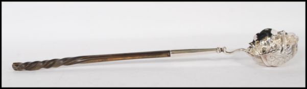 A George II John Pollock silver hallmarked toddy ladle having a shaped bowl with repousse grape vine