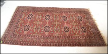 A 19th century Persian / Islamic Bokhara rug with red ground having geometric decoration to the