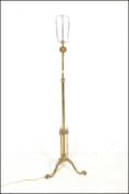 An early 20th Century Edwardian brass adjustable telescopic standard lamp being raised on three