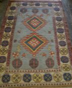 A 20th Century oriental woven blue ground geometric floor rug having a central blue panel with a
