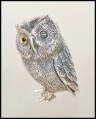 An unusual silver figurine  of an owl with glass eyes. Weight 18.0g.