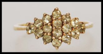 A stamped 375 9ct gold cluster ring set with round cut green stones to the head. Weight 2.5g. Size