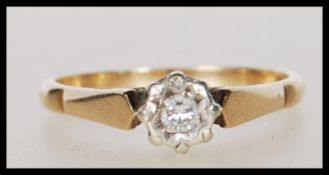 A hallmarked 9ct gold and diamond solitaire ring being illusion set with a brilliant cut diamond.