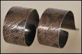A pair of 20th Century hallmarked silver napkin rings of unusual open scrolled form having