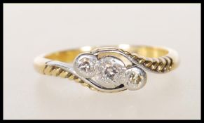 A stamped 18ct gold and platinum Art Deco cross over ring illusion set with three round cut