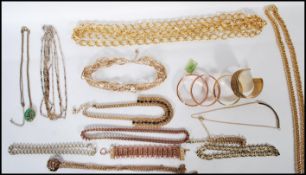 A group of gold tone jewellery necklaces and decorative bangles, various designs to include flat