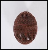 A 20th Century carved coquilla nut pomander case being carved with concentric circle patterning with
