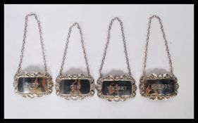 A set of 4 silver hallmarked decanter labels to include Whisky, Gin, Sherry & Port. Hallmarked for