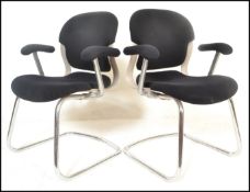 A pair of 20th Century open framed cantilever armchairs, raised on chrome tubular cantilever