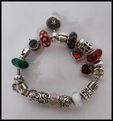 A stamped 925 silver Pandora charm bracelet having a snake chain with 17 silver charms and safety