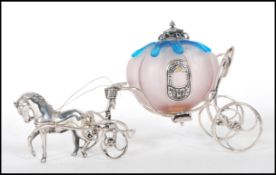 A stamped 925 silver ornament in the form of a cinderella horse drawn carriage having a pink and