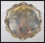 A silver hallmarked salver tray by Mappin & Webb being raised on claw and ball feet. Hallmarked