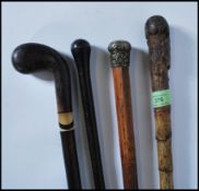 A group of three walking stick cannes to include a bamboo stick having a silver white metal knop,