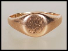 An early 20th Century hallmarked 9ct gold signet ring having a round panel to the head engraved