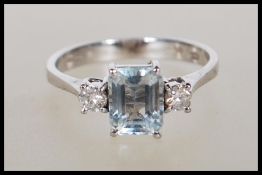 An 18ct white gold aquamarine and diamond ring, The cushion cut aquamarine with two round